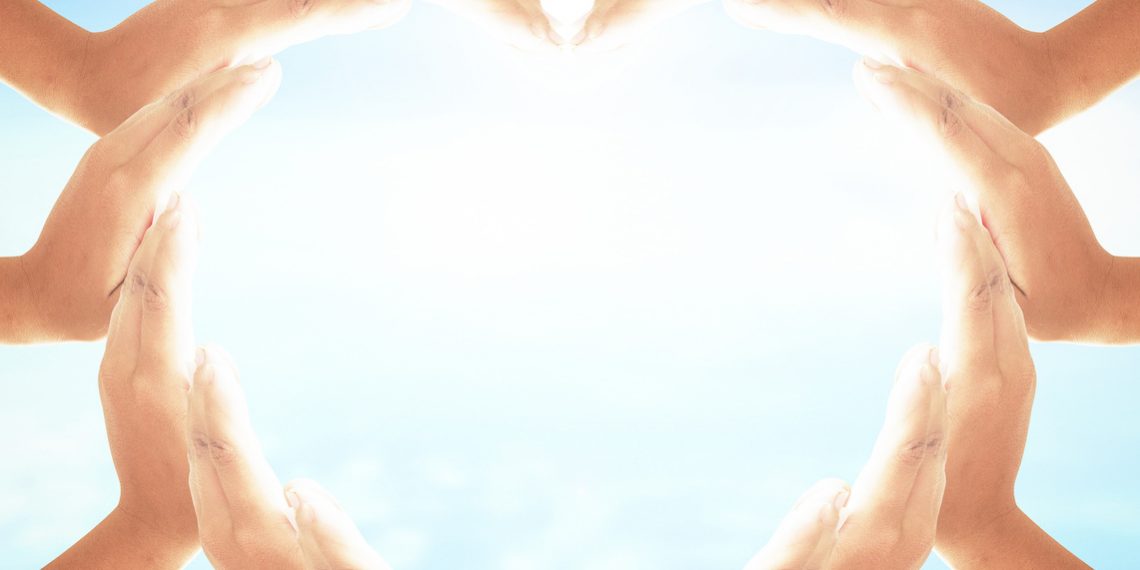 World environment day concept: Two Human hands show heart shape on blurred blue nature background
